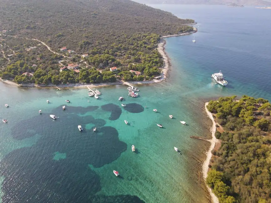 Aerial view of nautical transport on ocean with pure water between islands with woods